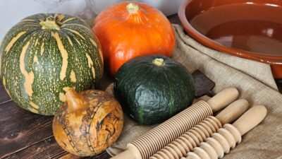 Zucche e oggetti della cucina: forme diverse riunite in una composizione fotografica.